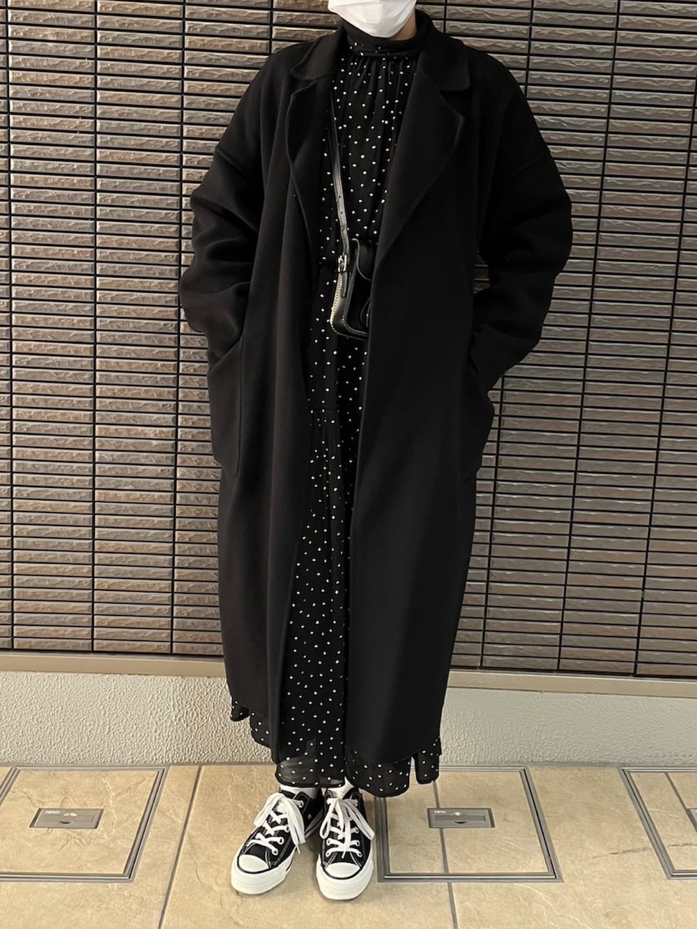 ブラック系のワンピース、ブラック系のショルダーバッグ、ブラック系のスニーカーを着用したレディースの冬コーディネートの2枚目の写真