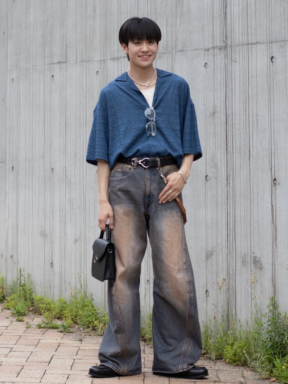 ピンク系のデニムパンツ、ブラック系のショルダーバッグ、ブラック系のローファーを着用したメンズの春コーディネートの4枚目の写真
