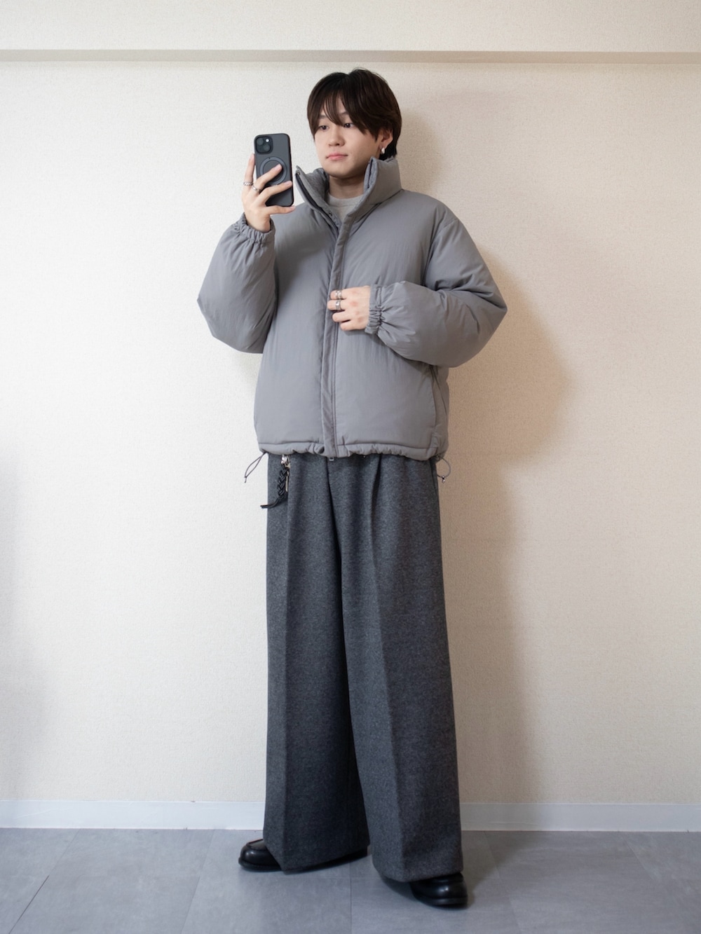 グレー系のスラックス、グレー系のダウンジャケット/コート、ブラック系のローファーを着用したメンズの秋コーディネートの3枚目の写真