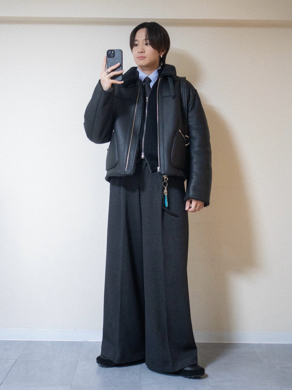 ブルー系のシャツ/ブラウス、ブラック系のニット/セーター、グレー系のスラックスを着用したメンズの冬コーディネートの2枚目の写真