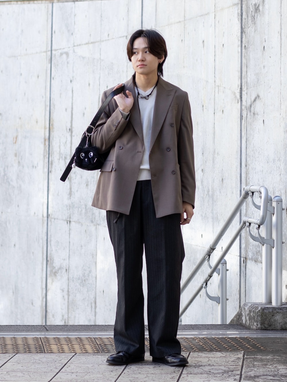 ホワイト系のニット/セーター、グレー系のスラックス、ベージュ系のスーツセットを着用したメンズの冬コーディネートの2枚目の写真