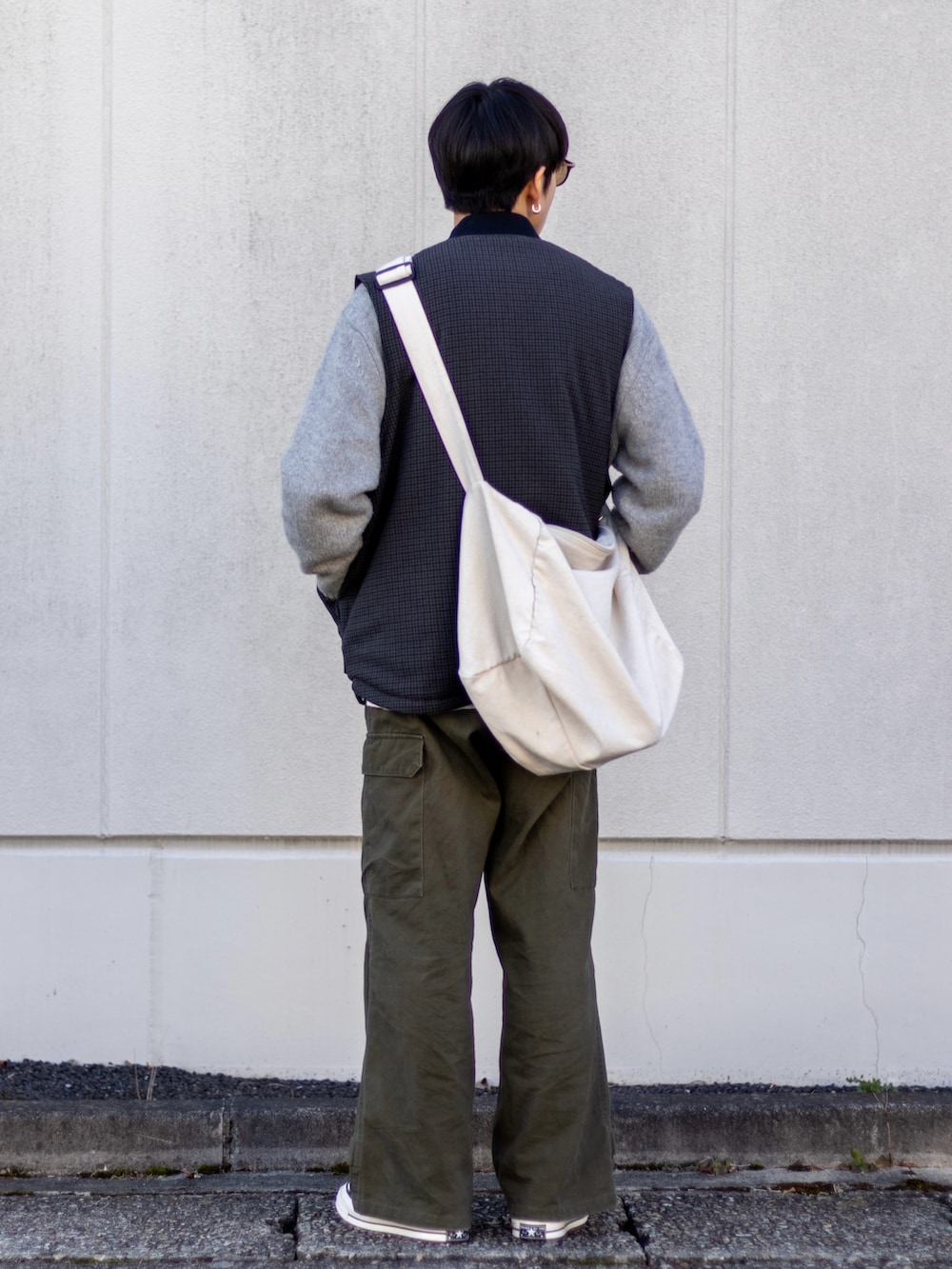 グリーン系のカーゴパンツ、ブラック系のスニーカー、グレー系のニット/セーターを着用したメンズの冬コーディネートの3枚目の写真