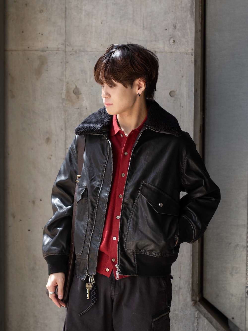 レッド系のシャツ/ブラウス、ブラック系のブルゾン、グレー系のカーゴパンツを着用したメンズの秋コーディネートの3枚目の写真