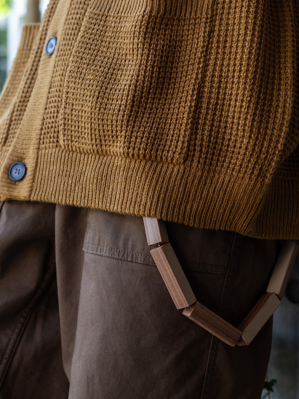 ブラウン系のパンツ、イエロー系のカーディガン/ボレロ、ブラウン系のメッセンジャーバッグを着用したメンズの秋コーディネートの3枚目の写真