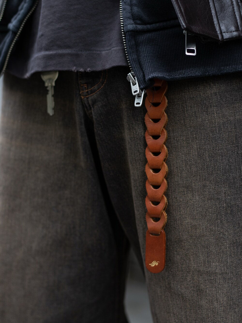 ブラック系のデニムパンツ、ブラック系のドレスシューズ、ブラウン系のブルゾンを着用したメンズの秋コーディネートの4枚目の写真