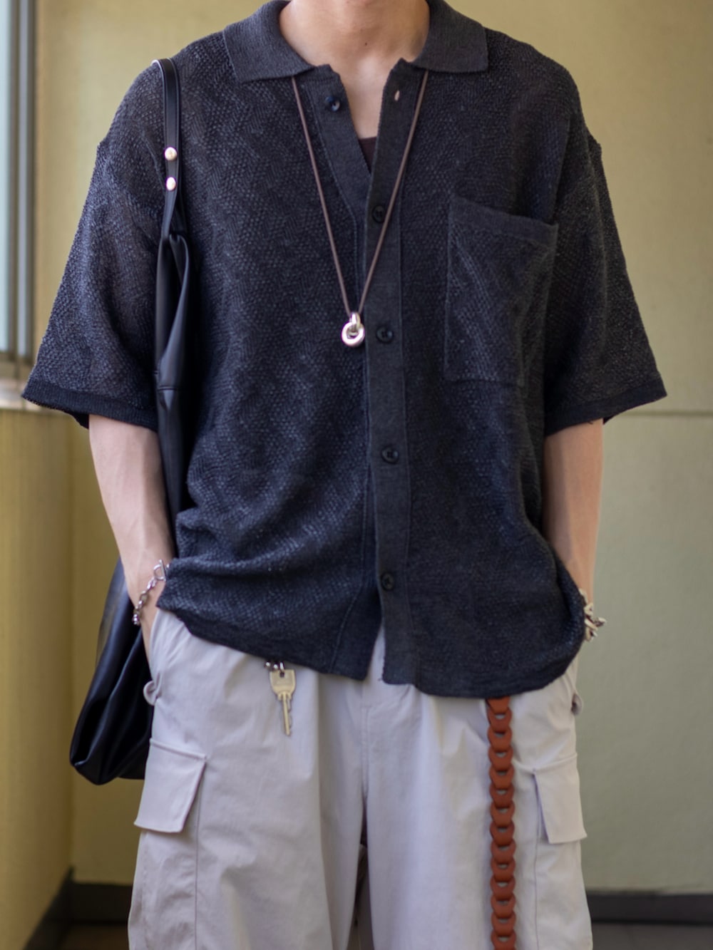 グレー系のカーゴパンツ、ブラック系のサンダル、ブラック系のトートバッグを着用したメンズの夏コーディネートの2枚目の写真