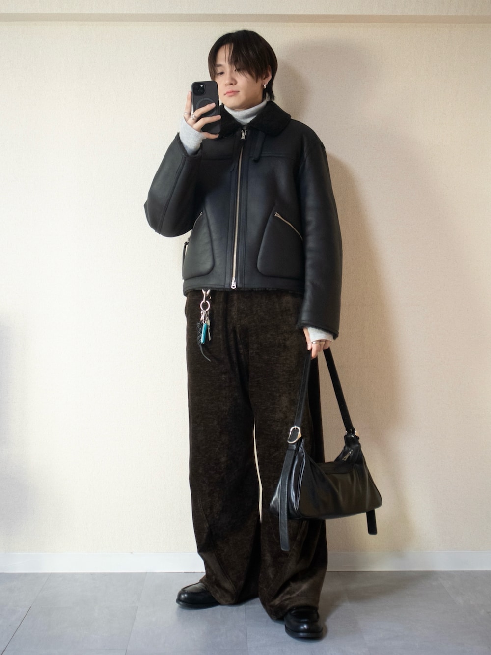 グレー系のニット/セーター、ブラウン系のその他パンツ、ブラック系のショルダーバッグを着用したメンズの冬コーディネートの2枚目の写真