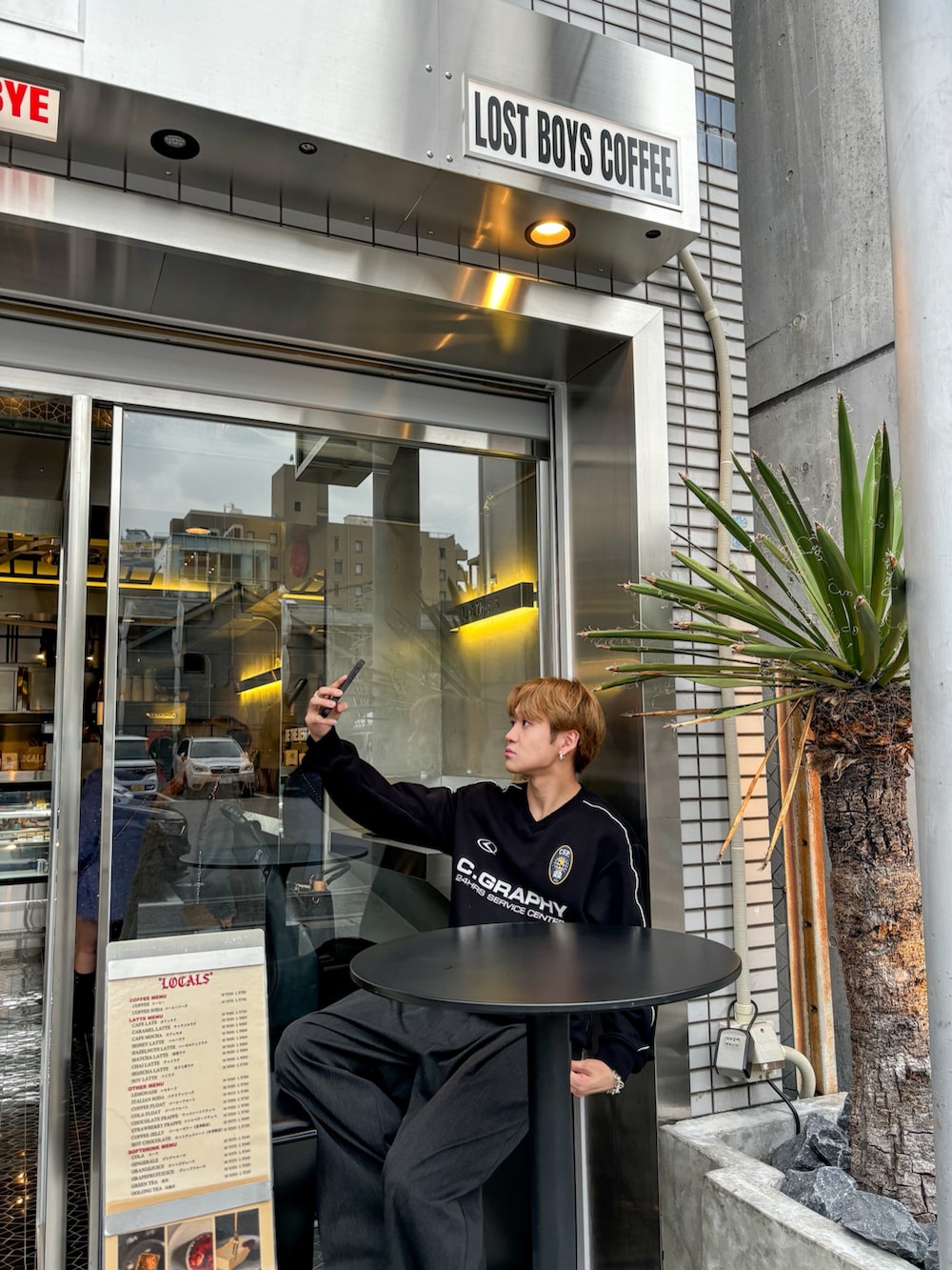 ブラック系のスウェット、グレー系のスラックス、ブラック系のボディバッグ/ウエストポーチを着用したメンズの秋コーディネートの4枚目の写真