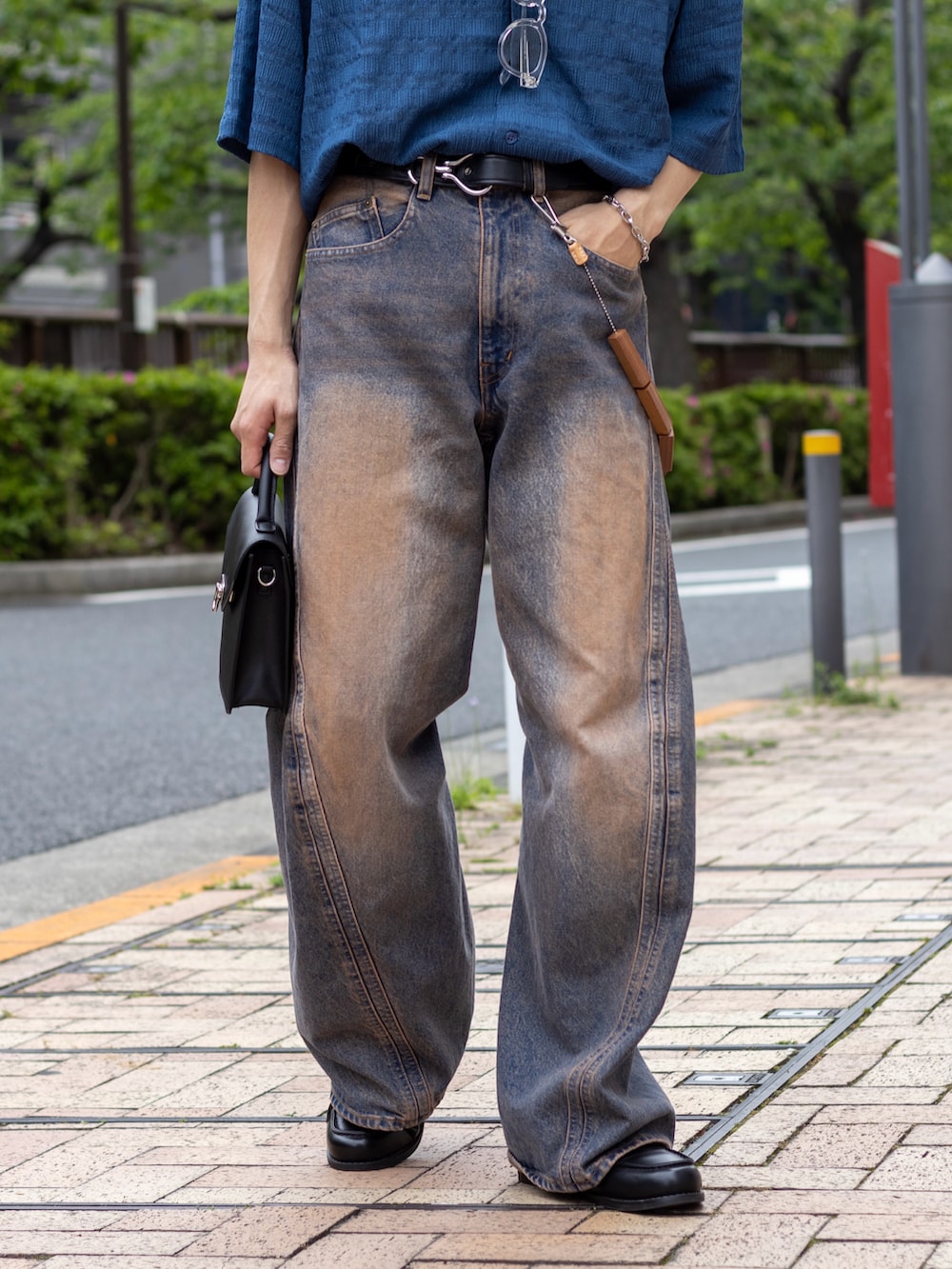 ピンク系のデニムパンツ、ブラック系のショルダーバッグ、ブラック系のローファーを着用したメンズの春コーディネートの3枚目の写真
