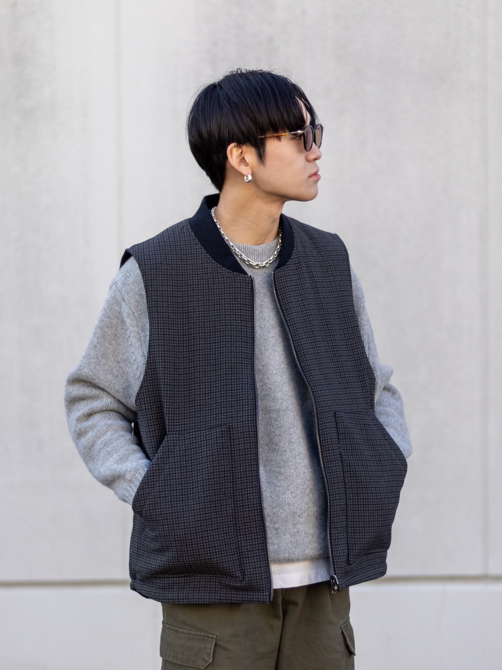 グリーン系のカーゴパンツ、ブラック系のスニーカー、グレー系のニット/セーターを着用したメンズの冬コーディネートの5枚目の写真