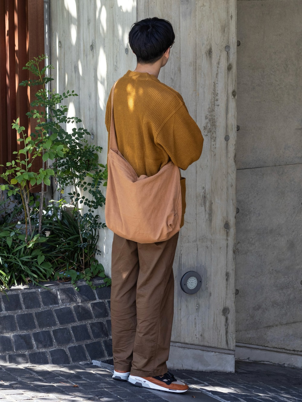 ブラウン系のパンツ、イエロー系のカーディガン/ボレロ、ブラウン系のメッセンジャーバッグを着用したメンズの秋コーディネートの5枚目の写真