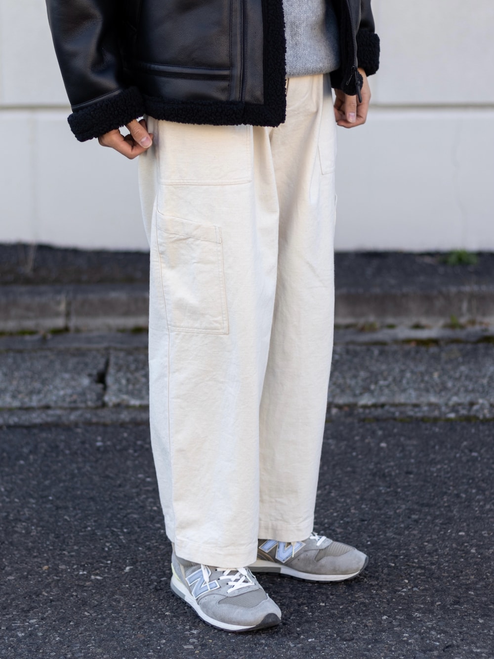 ホワイト系のカーゴパンツ、グレー系のスニーカー、グレー系のニット/セーターを着用したメンズの冬コーディネートの3枚目の写真