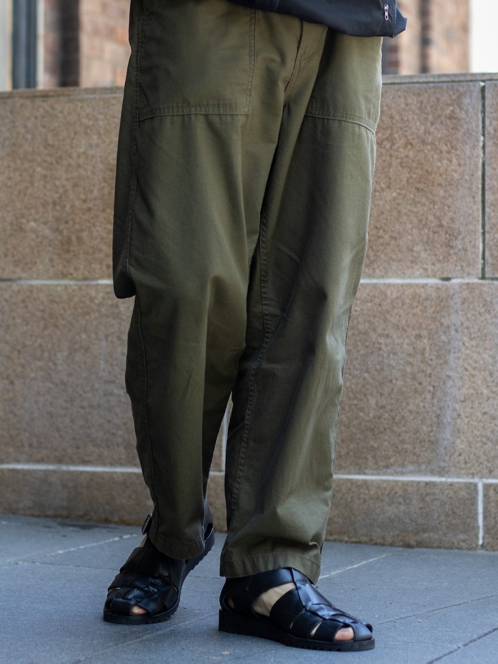 ブラック系のベスト、グリーン系のその他パンツ、ブラック系のサンダルを着用したメンズの夏コーディネートの5枚目の写真