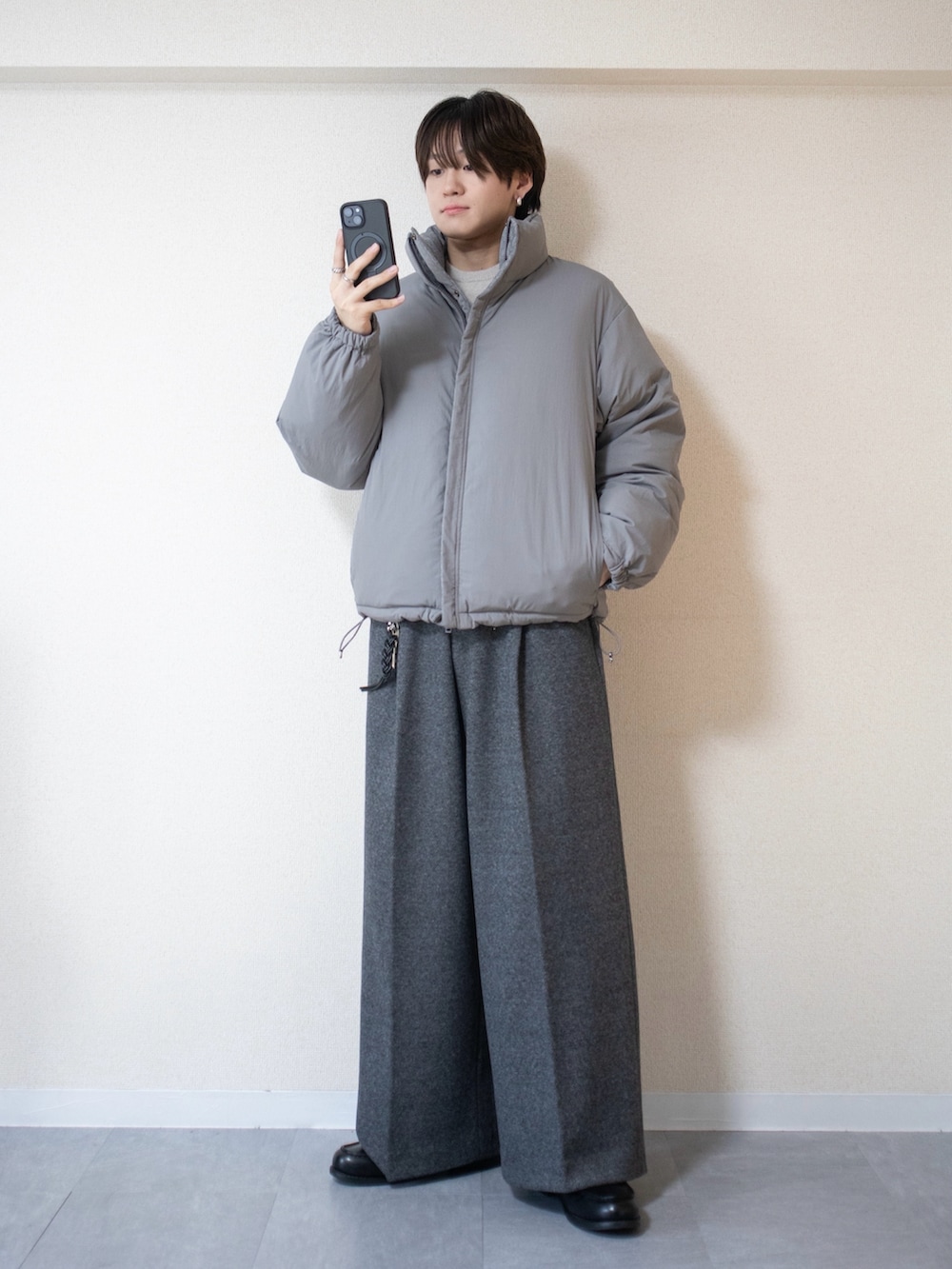 グレー系のスラックス、グレー系のダウンジャケット/コート、ブラック系のローファーを着用したメンズの秋コーディネートの2枚目の写真