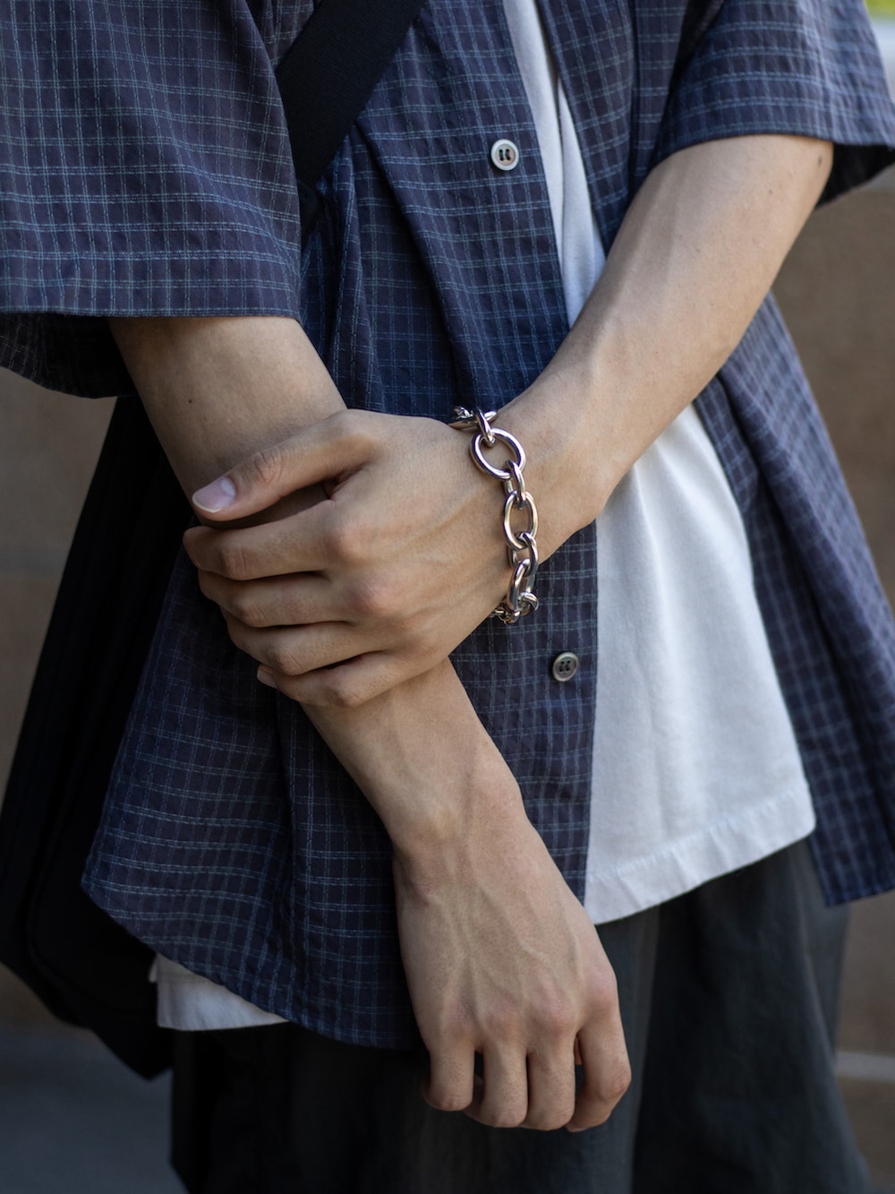 ブラック系のショルダーバッグ、ブラック系のサンダル、グレー系のパンツを着用したメンズの夏コーディネートの4枚目の写真