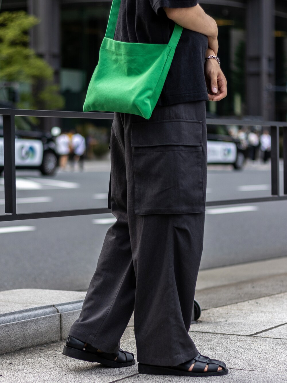 グレー系のカーゴパンツ、グリーン系のショルダーバッグ、ブラック系のサンダルを着用したメンズの夏コーディネートの4枚目の写真