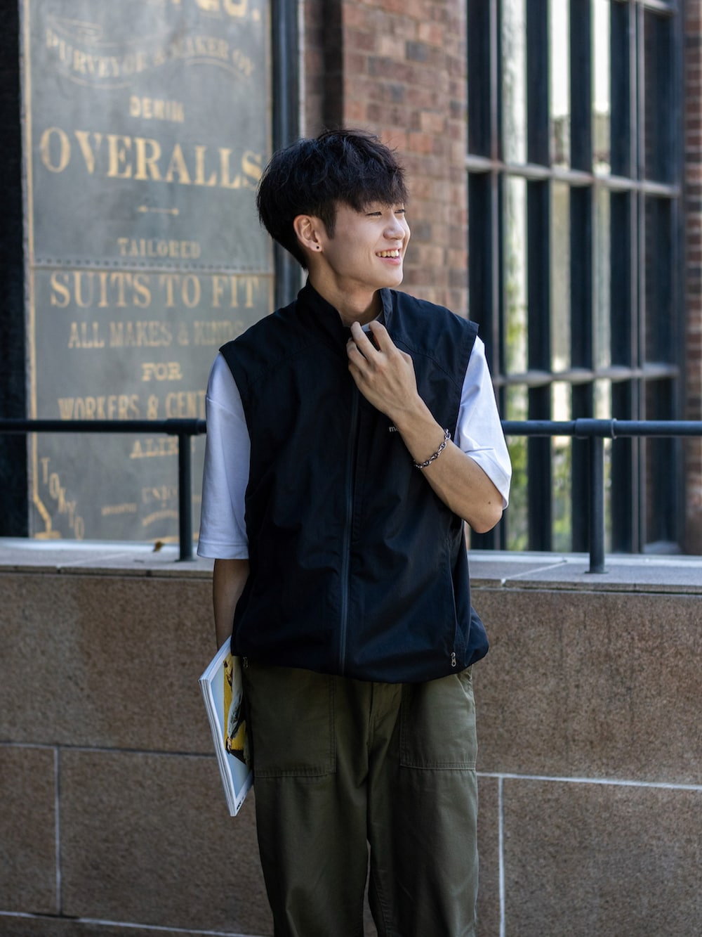 ブラック系のベスト、グリーン系のその他パンツ、ブラック系のサンダルを着用したメンズの夏コーディネートの2枚目の写真