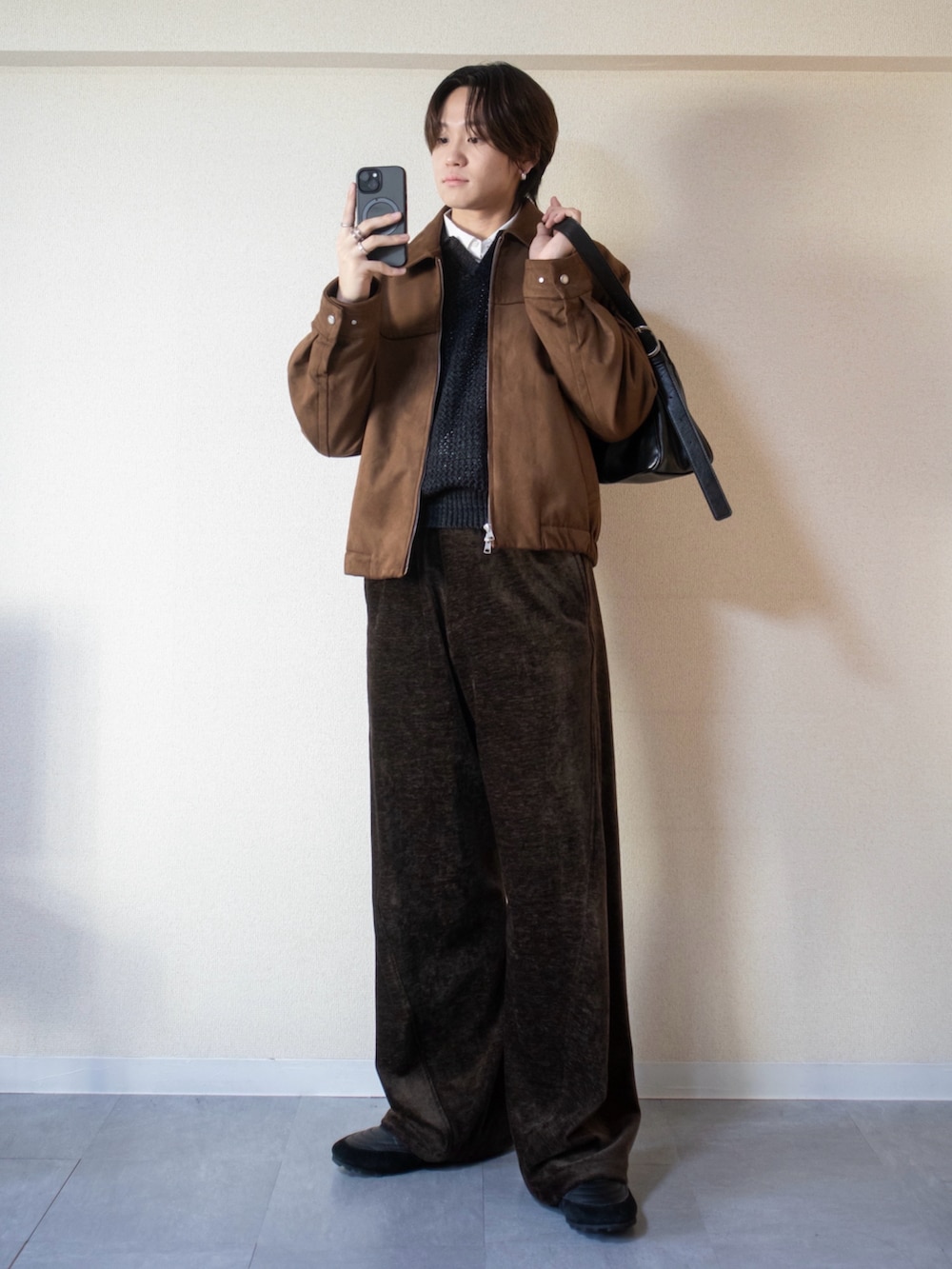 グレー系のニット/セーター、ブラウン系のブルゾン、ブラウン系のその他パンツを着用したメンズの冬コーディネートの2枚目の写真