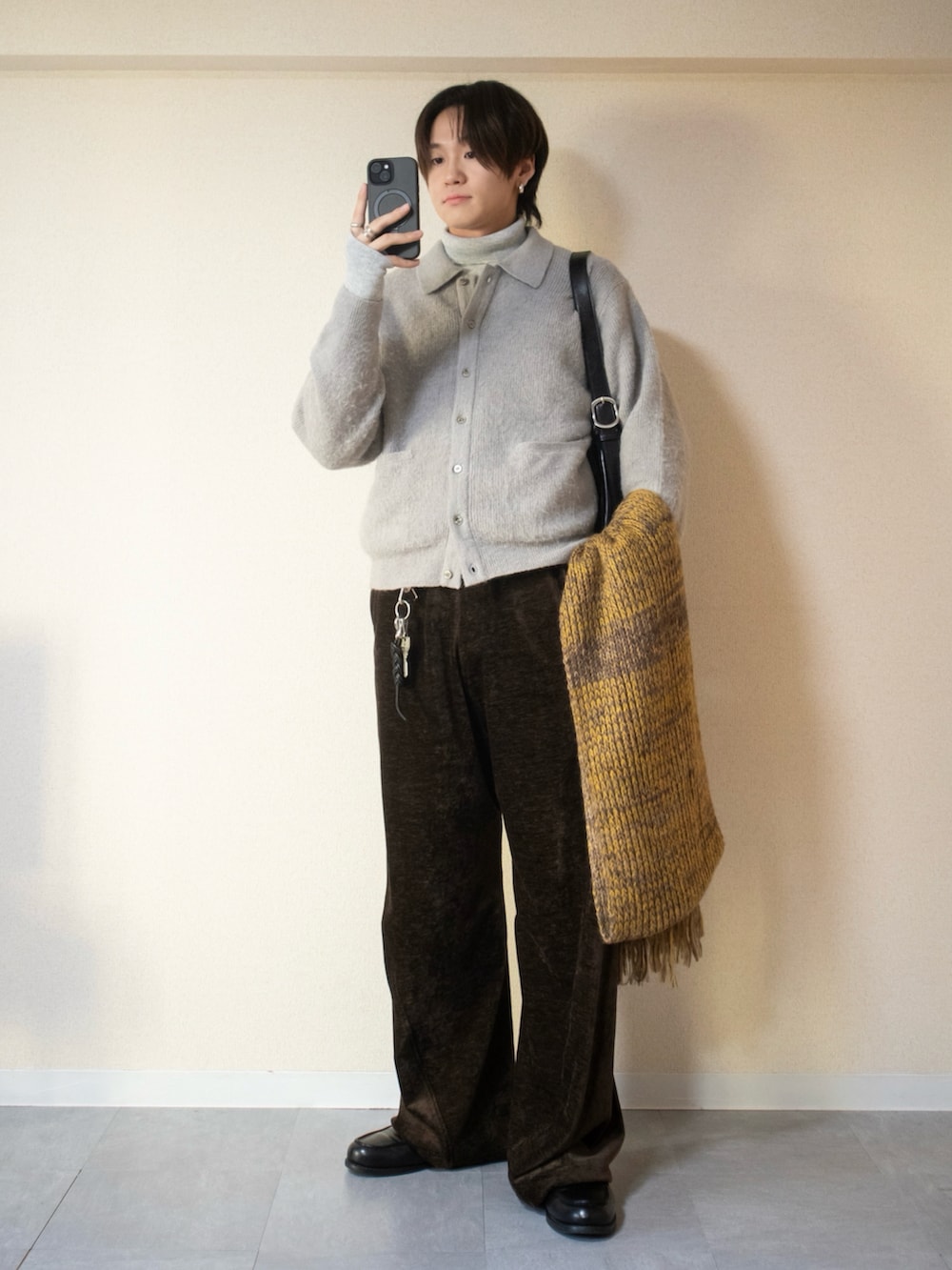 グレー系のニット/セーター、グレー系のニット/セーター、ブラック系のステンカラーコートを着用したメンズの冬コーディネートの2枚目の写真