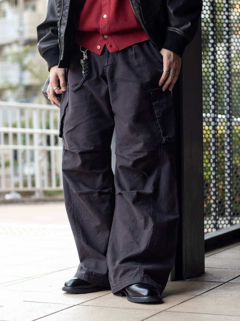 レッド系のシャツ/ブラウス、ブラック系のブルゾン、グレー系のカーゴパンツを着用したメンズの秋コーディネートの4枚目の写真