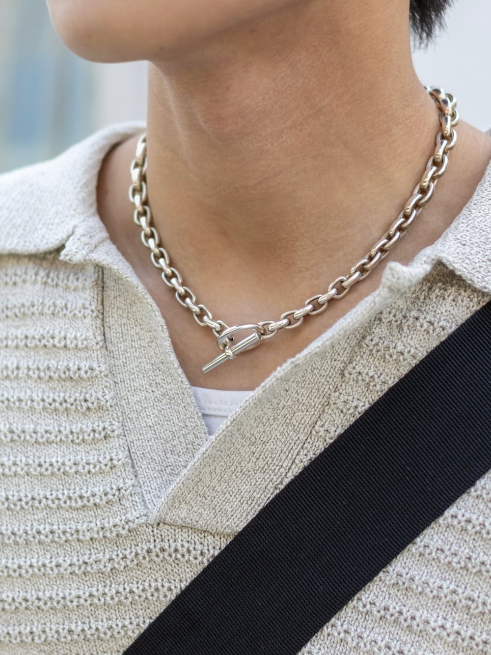 ブラック系のカーゴパンツ、ブラック系のスニーカー、ブラック系のメッセンジャーバッグを着用したメンズの春コーディネートの4枚目の写真