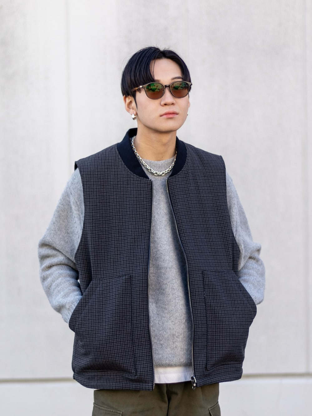 グリーン系のカーゴパンツ、ブラック系のスニーカー、グレー系のニット/セーターを着用したメンズの冬コーディネートの2枚目の写真