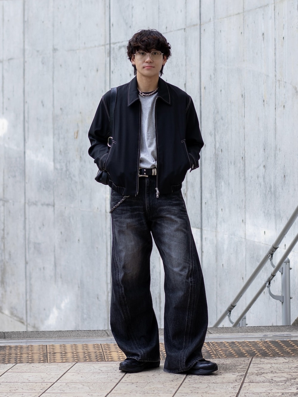 グレー系のTシャツ/カットソー、ブラック系のブルゾン、ブラック系のスニーカーを着用したメンズの春コーディネートの2枚目の写真