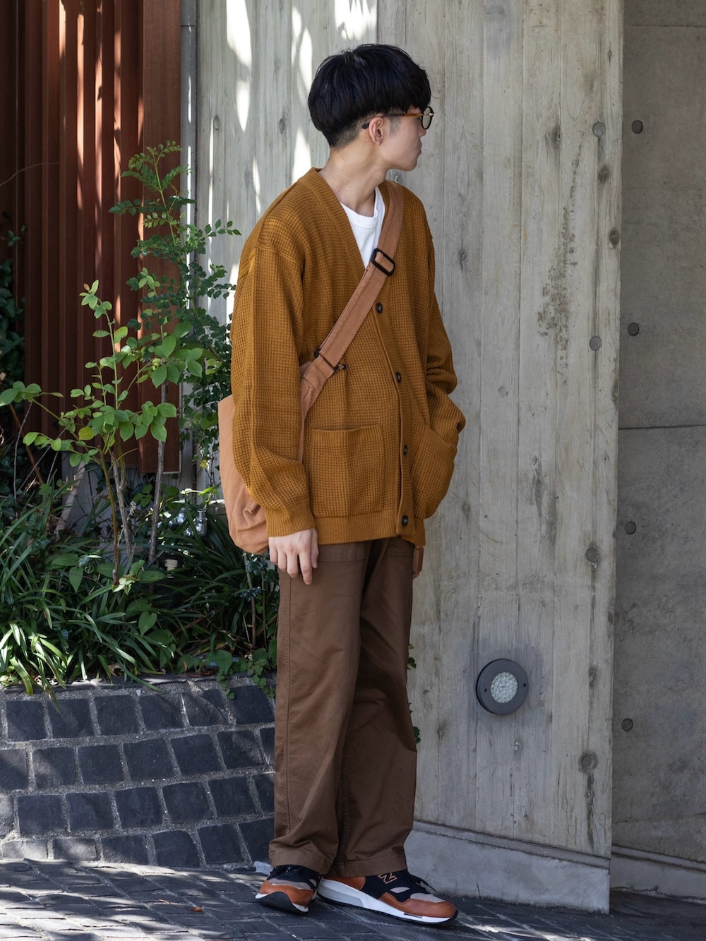 ブラウン系のパンツ、イエロー系のカーディガン/ボレロ、ブラウン系のメッセンジャーバッグを着用したメンズの秋コーディネートの2枚目の写真
