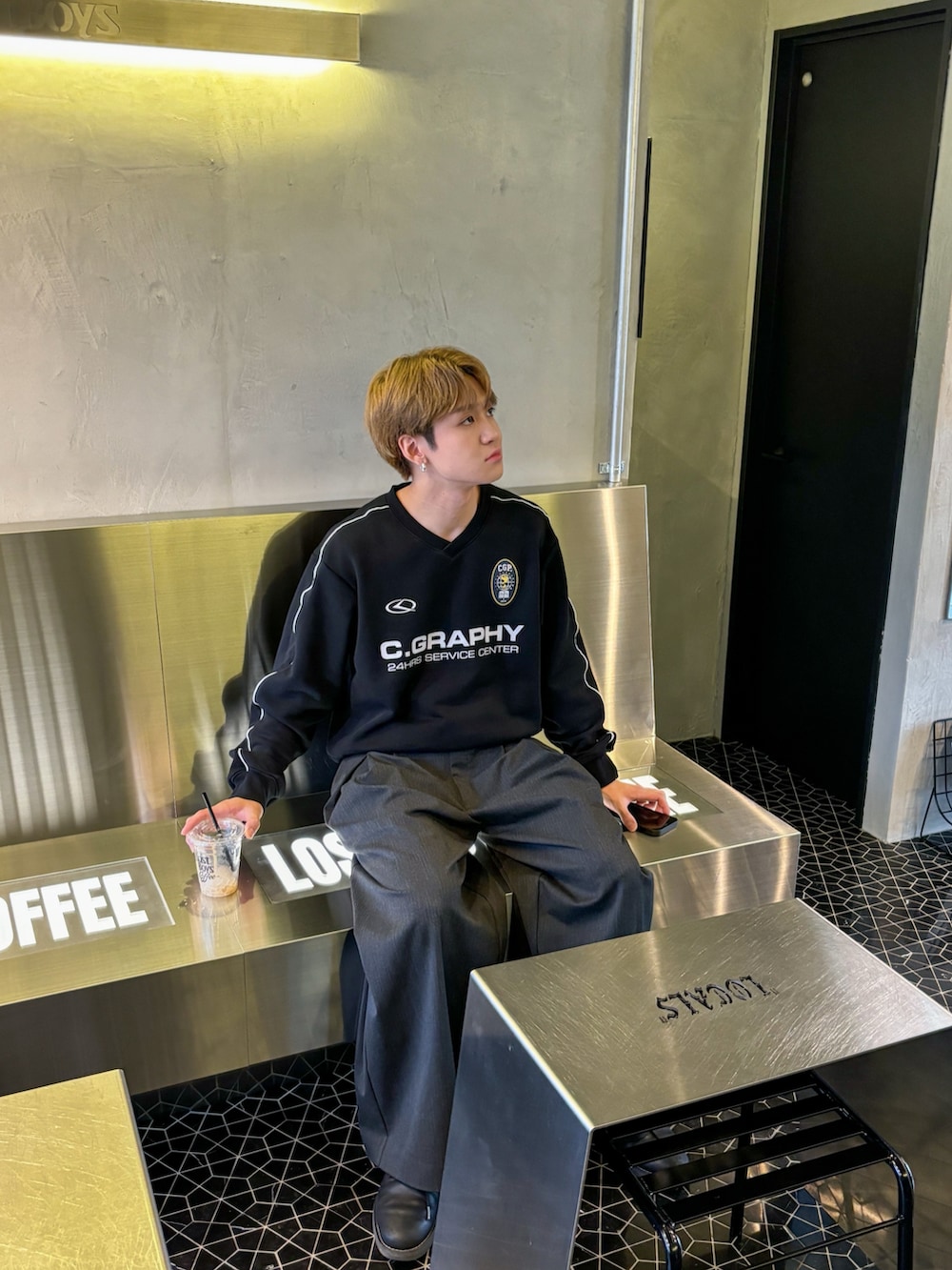 ブラック系のスウェット、グレー系のスラックス、ブラック系のボディバッグ/ウエストポーチを着用したメンズの秋コーディネートの3枚目の写真