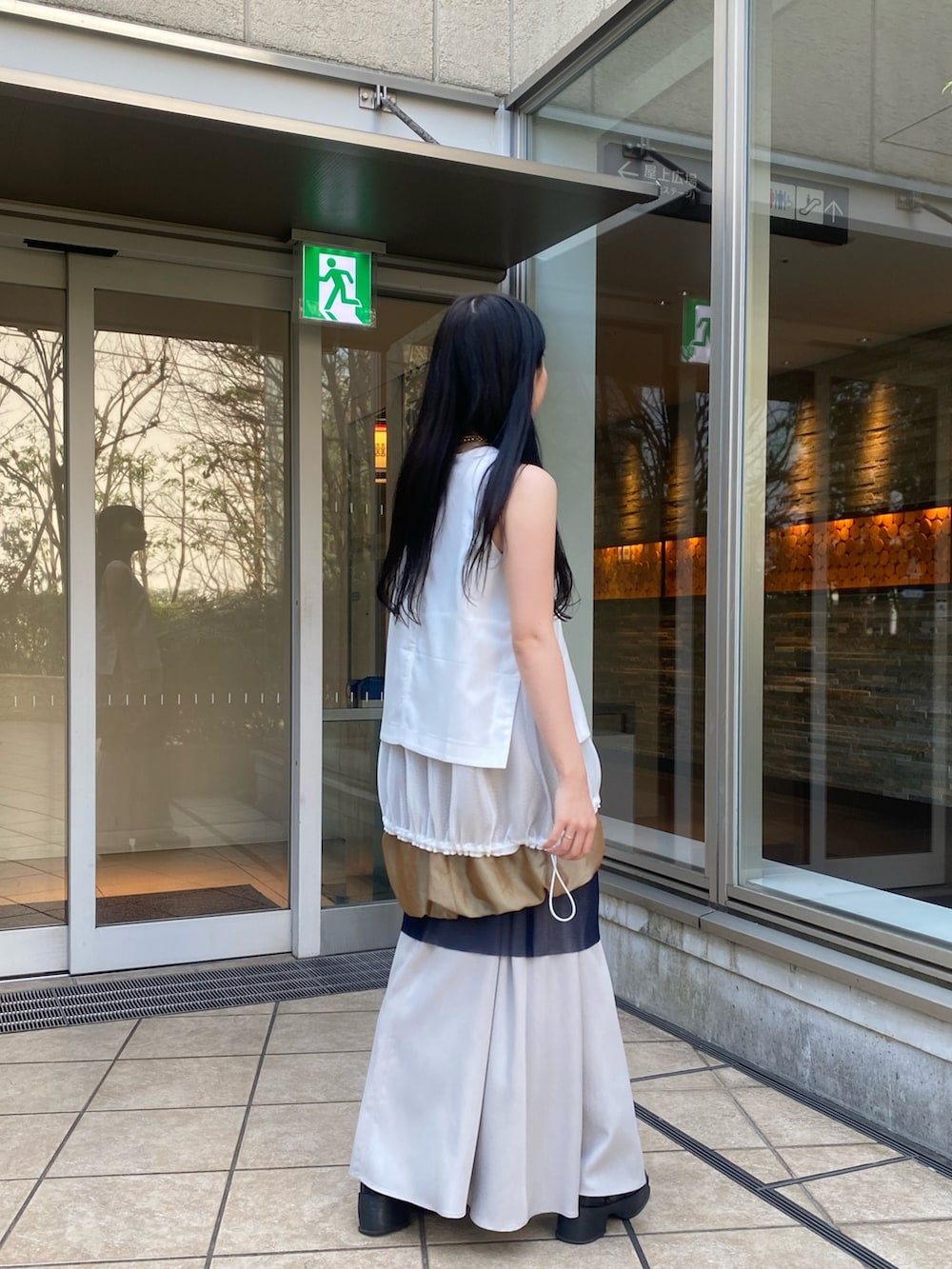 ホワイト系のタンクトップ、イエロー系のスカートを着用したレディースの春コーディネートの3枚目の写真