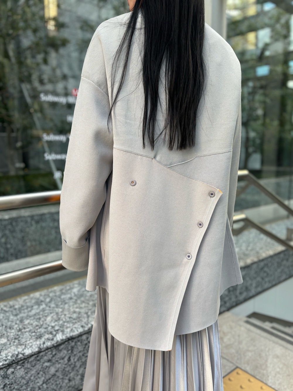 ホワイト系のシャツ/ブラウス、ベージュ系のニット/セーター、シルバー系のスカートを着用したレディースの冬コーディネートの6枚目の写真