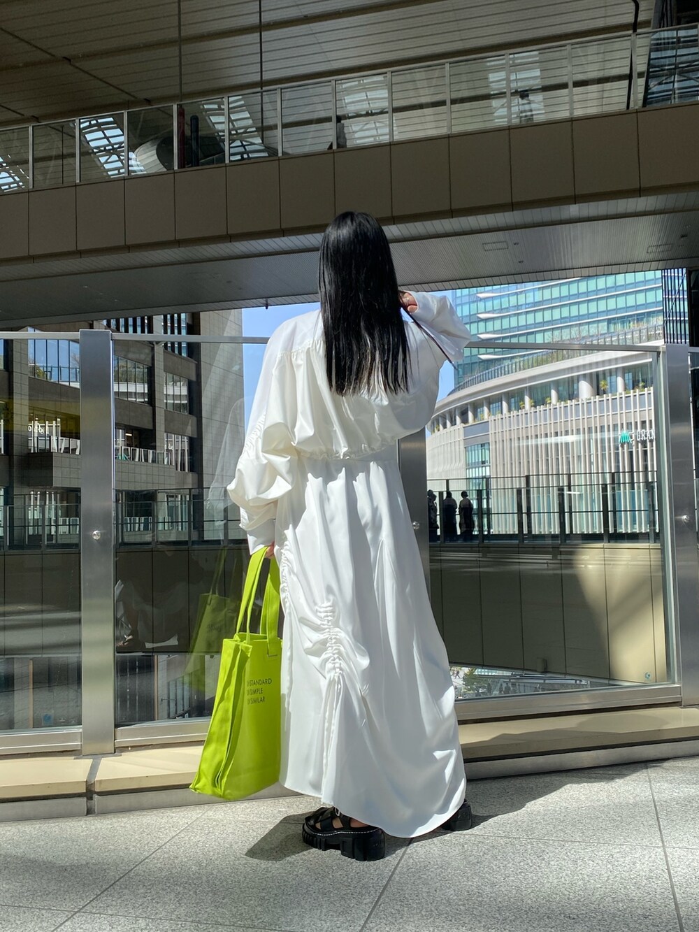 ホワイト系のTシャツ/カットソー、ホワイト系のワンピース、グリーン系のトートバッグを着用したレディースの春コーディネートの3枚目の写真