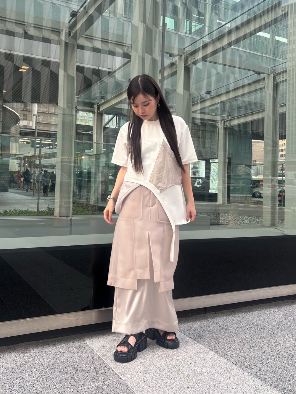 ホワイト系のTシャツ/カットソー、ベージュ系のスカート、ブラック系のサンダルを着用したレディースの春コーディネートの2枚目の写真