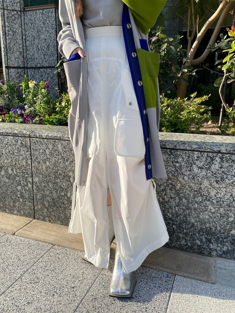 グレー系のニット/セーター、グレー系のカーディガン/ボレロ、ホワイト系のスカートを着用したレディースの冬コーディネートの7枚目の写真