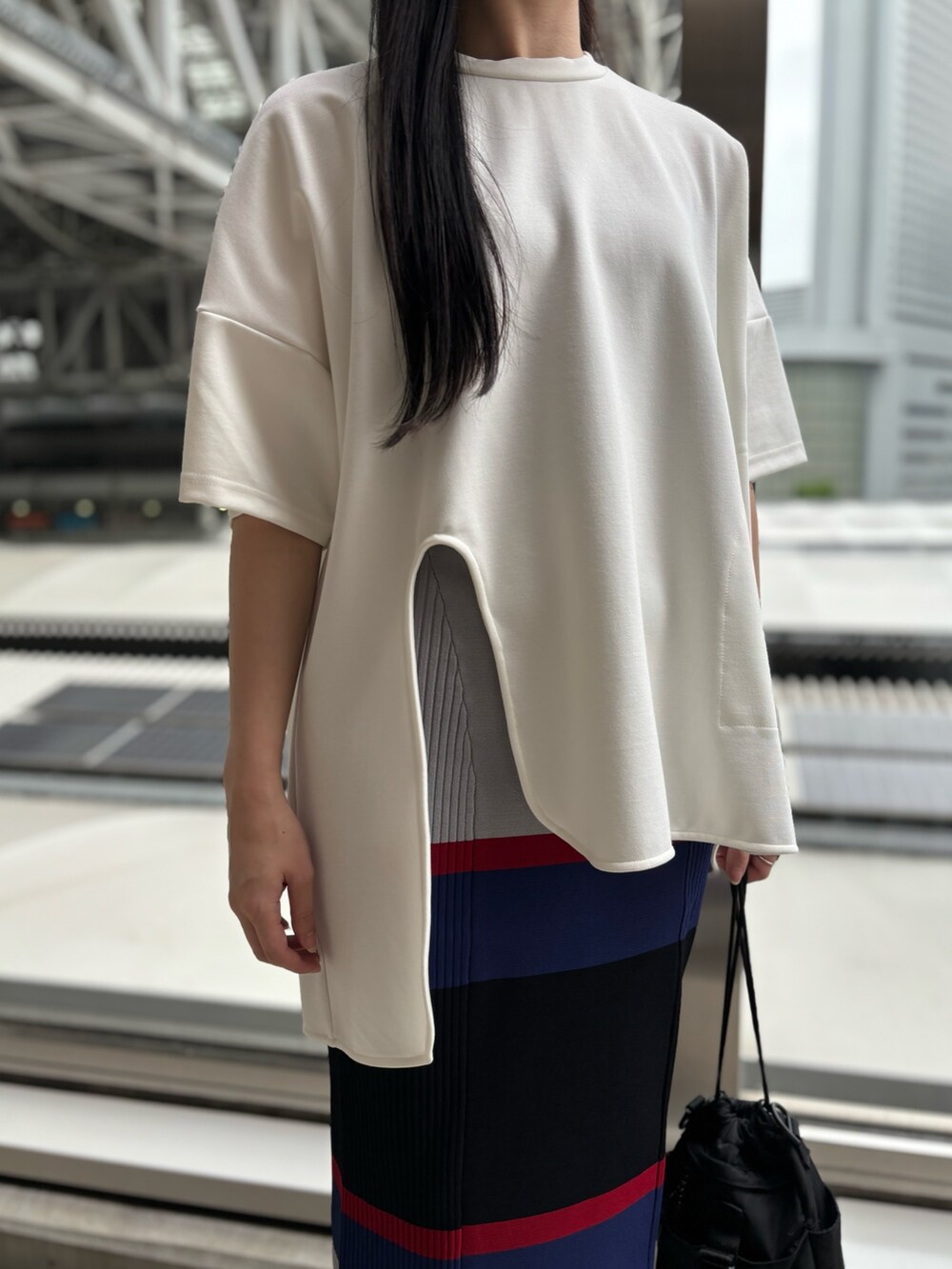 ホワイト系のTシャツ/カットソー、グレー系のスカートを着用したレディースの春コーディネートの6枚目の写真