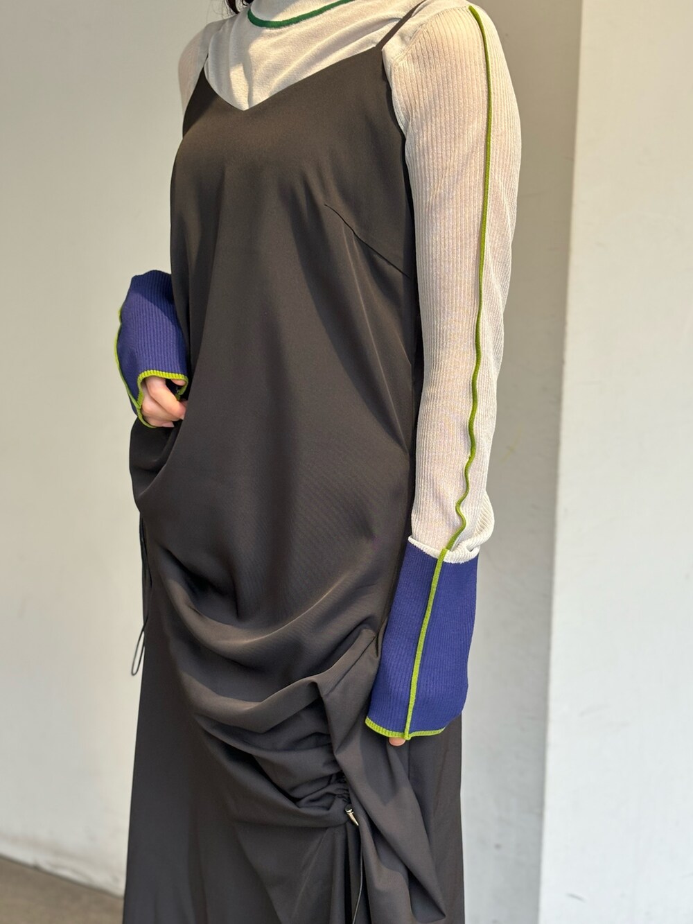 グレー系のニット/セーター、ブラック系のワンピース、シルバー系のパンプスを着用したレディースの春コーディネートの6枚目の写真