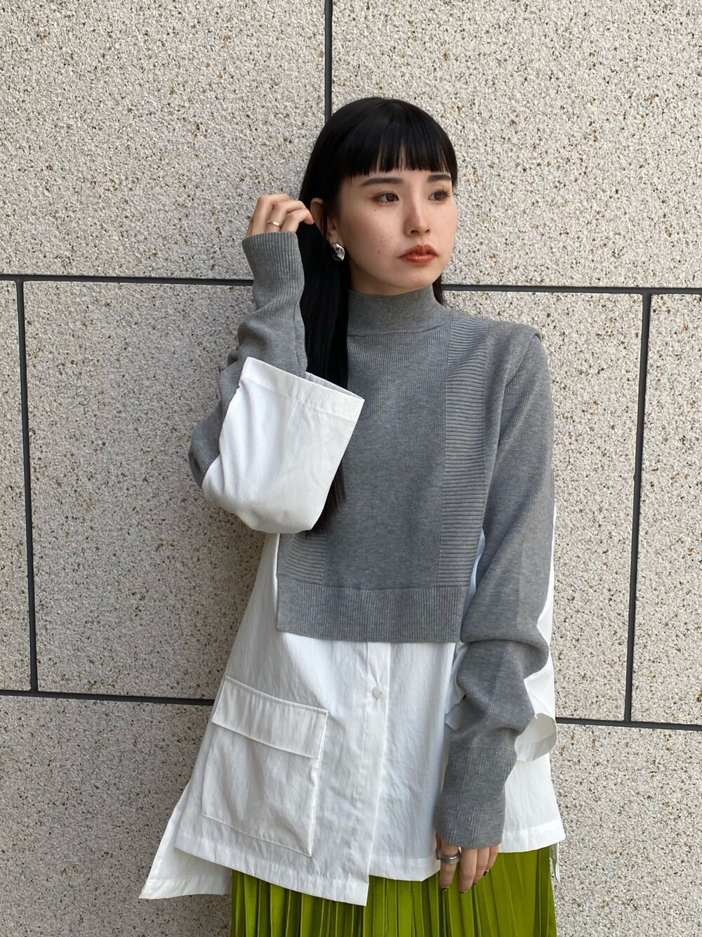 グレー系のニット/セーター、ブラック系のブーツ、グリーン系のスカートを着用したレディースの冬コーディネートの5枚目の写真