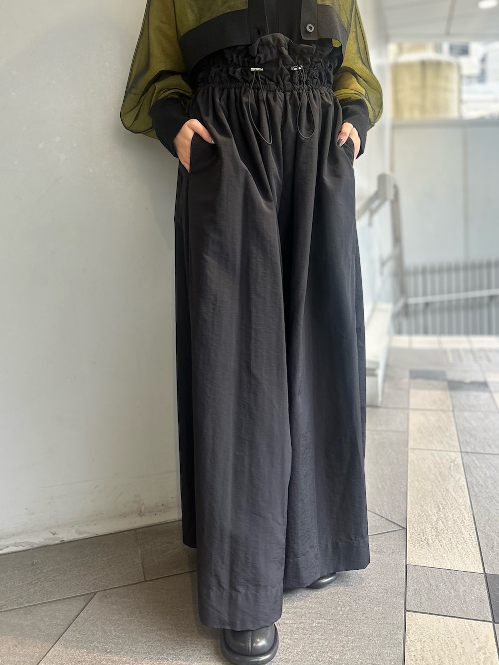 イエロー系のカーディガン/ボレロ、ブラック系のタンクトップ、ブラック系のその他パンツを着用したレディースの春コーディネートの7枚目の写真