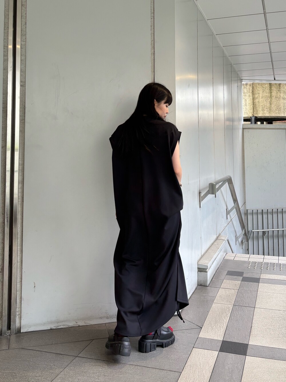 レッド系のタンクトップ、ブラック系のワンピース、シルバー系のイヤリングを着用したレディースの夏コーディネートの4枚目の写真