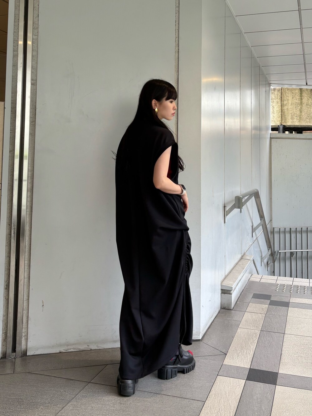 レッド系のタンクトップ、ブラック系のワンピース、シルバー系のイヤリングを着用したレディースの夏コーディネートの3枚目の写真