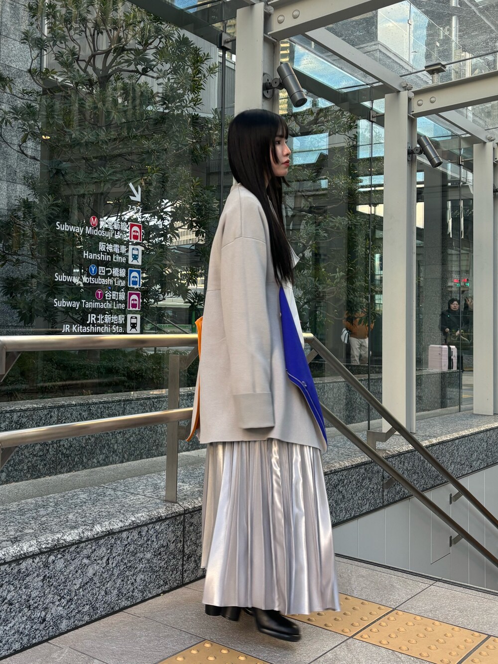 ホワイト系のシャツ/ブラウス、ベージュ系のニット/セーター、シルバー系のスカートを着用したレディースの冬コーディネートの2枚目の写真