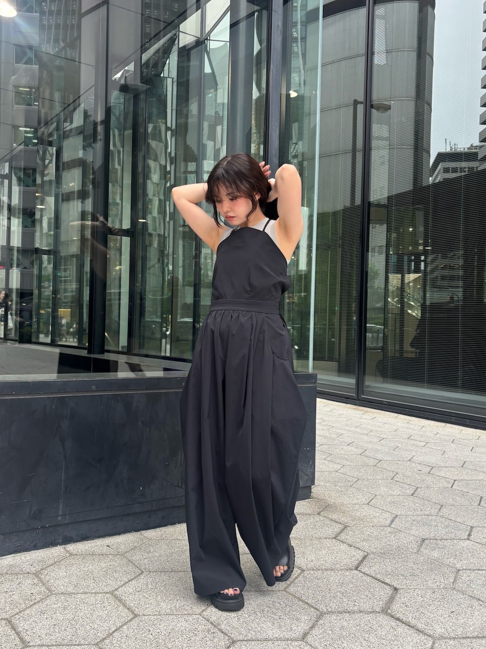 ブラック系のつなぎ/オールインワン、ベージュ系のタンクトップを着用したレディースの夏コーディネートの2枚目の写真