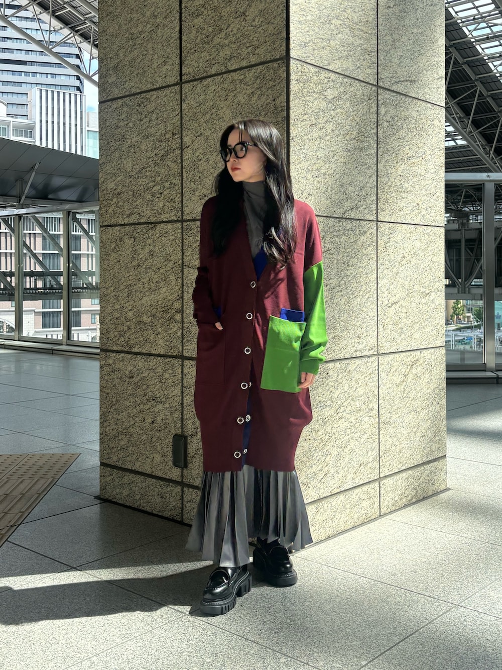 グレー系のTシャツ/カットソー、ブラウン系のカーディガン/ボレロ、グレー系のスカートを着用したレディースの秋コーディネートの2枚目の写真