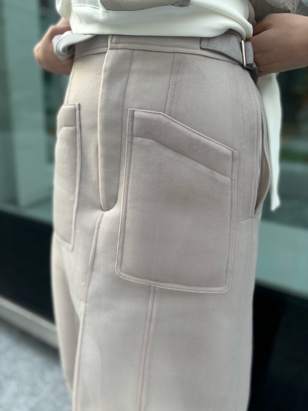 ホワイト系のTシャツ/カットソー、ベージュ系のスカート、ブラック系のサンダルを着用したレディースの春コーディネートの7枚目の写真