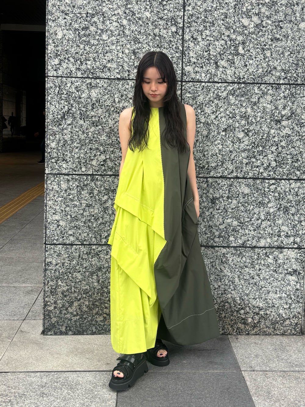 グリーン系のワンピース、ブラック系のサンダルを着用したレディースの春コーディネートの2枚目の写真