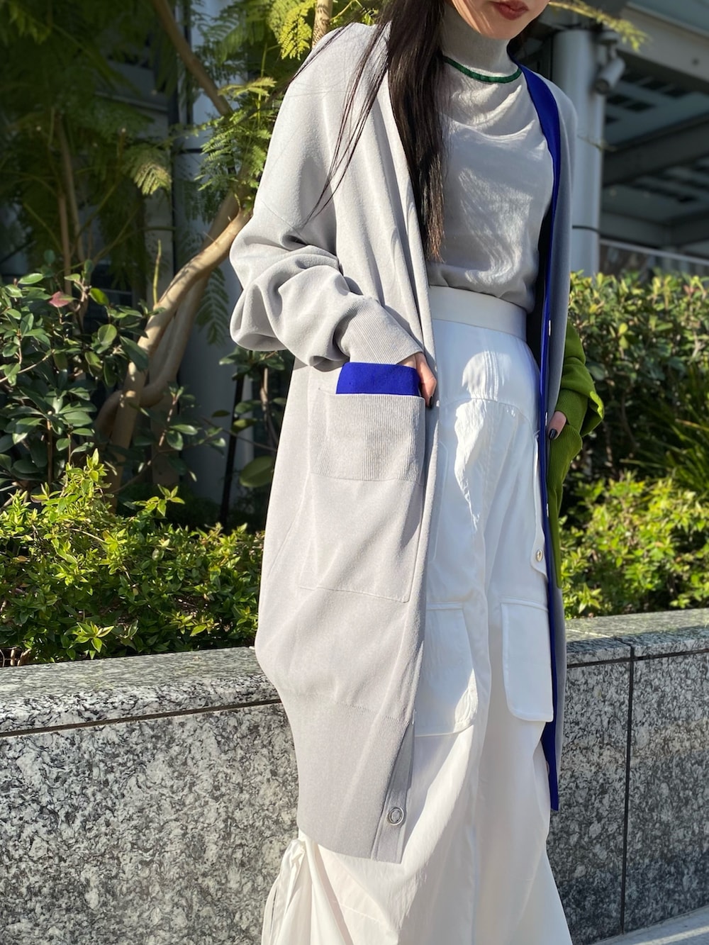 グレー系のニット/セーター、グレー系のカーディガン/ボレロ、ホワイト系のスカートを着用したレディースの冬コーディネートの6枚目の写真