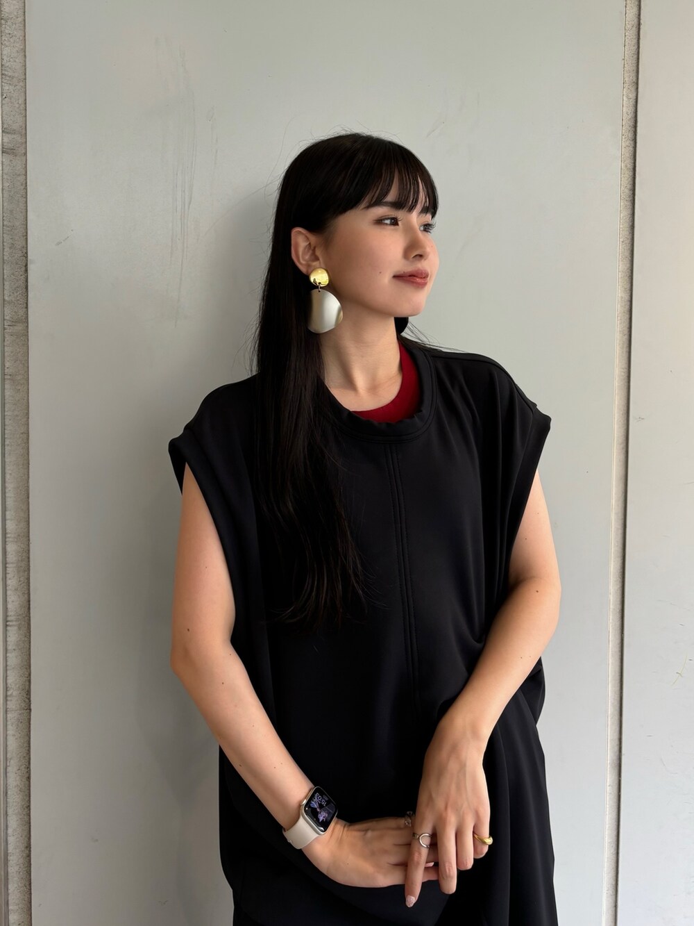 レッド系のタンクトップ、ブラック系のワンピース、シルバー系のイヤリングを着用したレディースの夏コーディネートの5枚目の写真