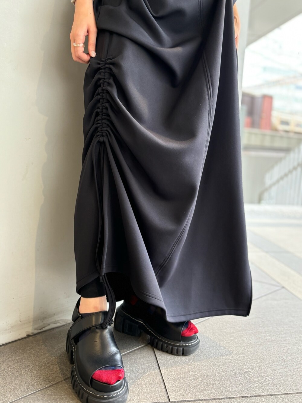 レッド系のタンクトップ、ブラック系のワンピース、シルバー系のイヤリングを着用したレディースの夏コーディネートの7枚目の写真