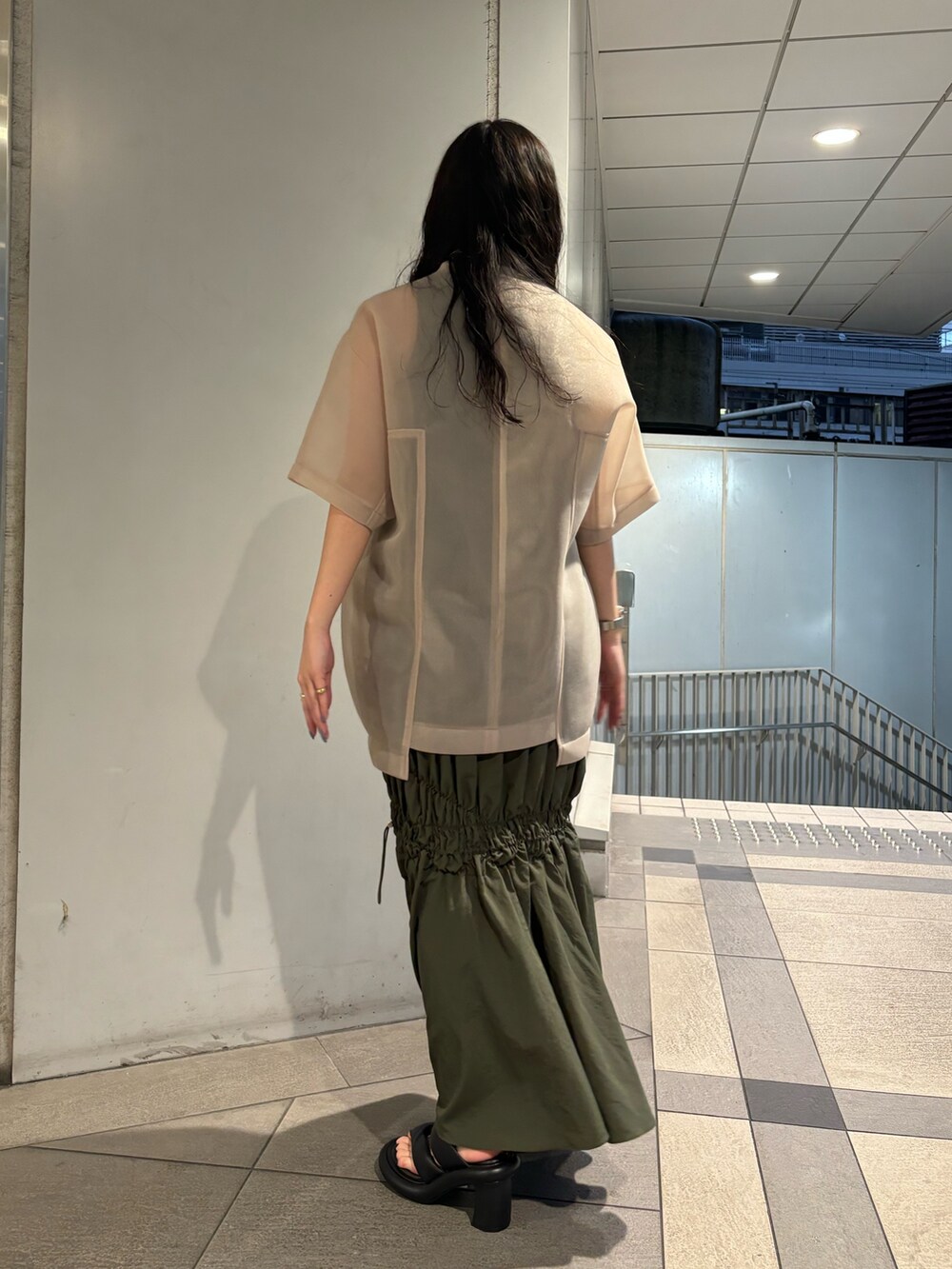 ベージュ系のTシャツ/カットソー、グリーン系のタンクトップ、グリーン系のスカートを着用したレディースの春コーディネートの3枚目の写真