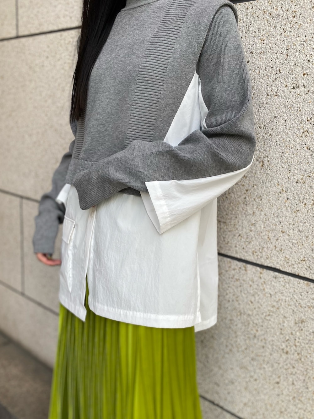 グレー系のニット/セーター、ブラック系のブーツ、グリーン系のスカートを着用したレディースの冬コーディネートの7枚目の写真